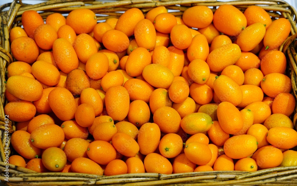 Basket of ripe orange kumquat citrus fruit
