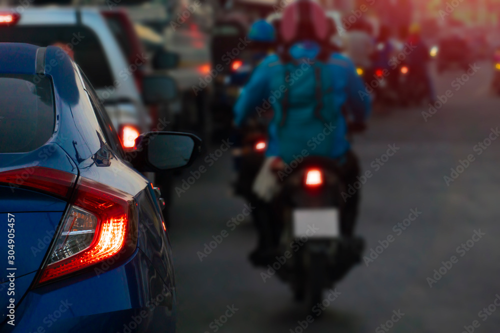 Luxury of blue car stop on the road and open brake light. with cars and other motorcycles on the road during heavy traffic with orange light
