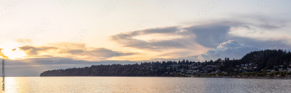 White Rock, British Columbia, Canada. Beautiful Panoramic View of Residential Homes on the Ocean Shore during a sunny and cloudy summer sunset.