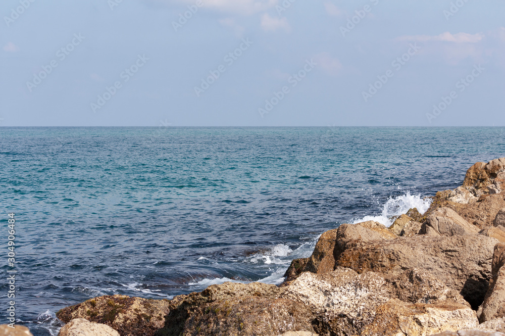 Stones and blue sea water as background