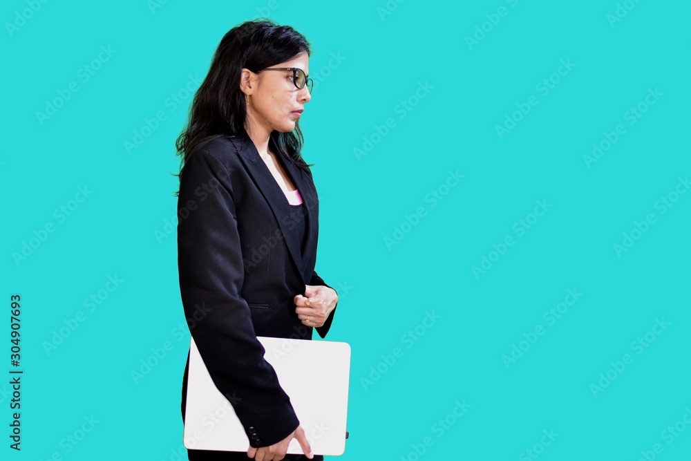 A beautiful office woman is carrying a laptop wearing black blazer. A beautiful office woman is carrying a laptop wearing black blazer.