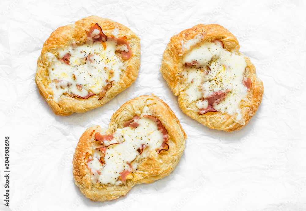 Puff pastry, ham, mozzarella cheese breakfast pizza on a light background, top view