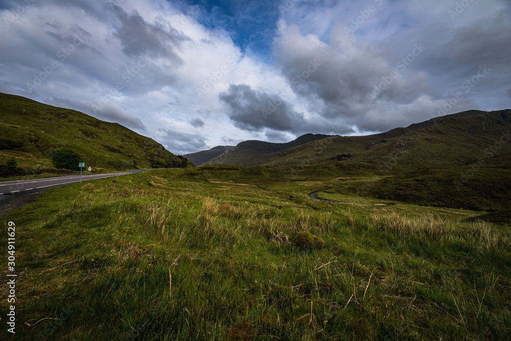 Beautiful scenic landscape of amazing Scotland nature and mountain trail road.