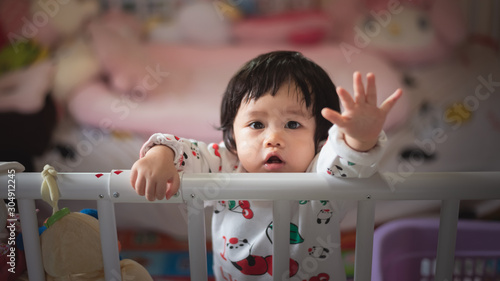 portrait of cute baby in child barrier