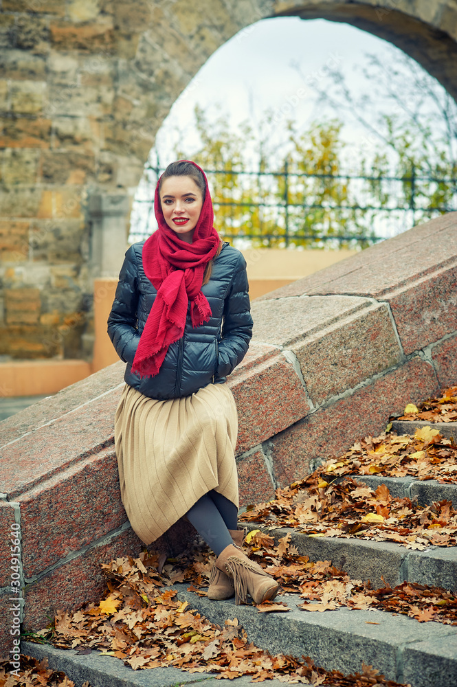 Beautiful young woman on an autumn walk in the old town