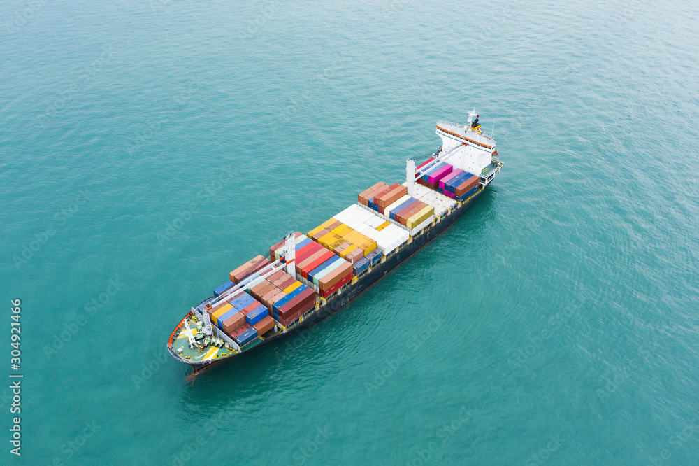 Stunning aerial view of a cargo ship sailing with hundreds of colored containers direct to the port of Singapore. The Port of Singapore is the second biggest port in the world.