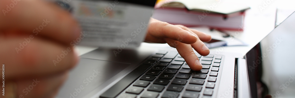 Male arms hold credit card press buttons making transfer Male arms hold credit card press buttons making transfer