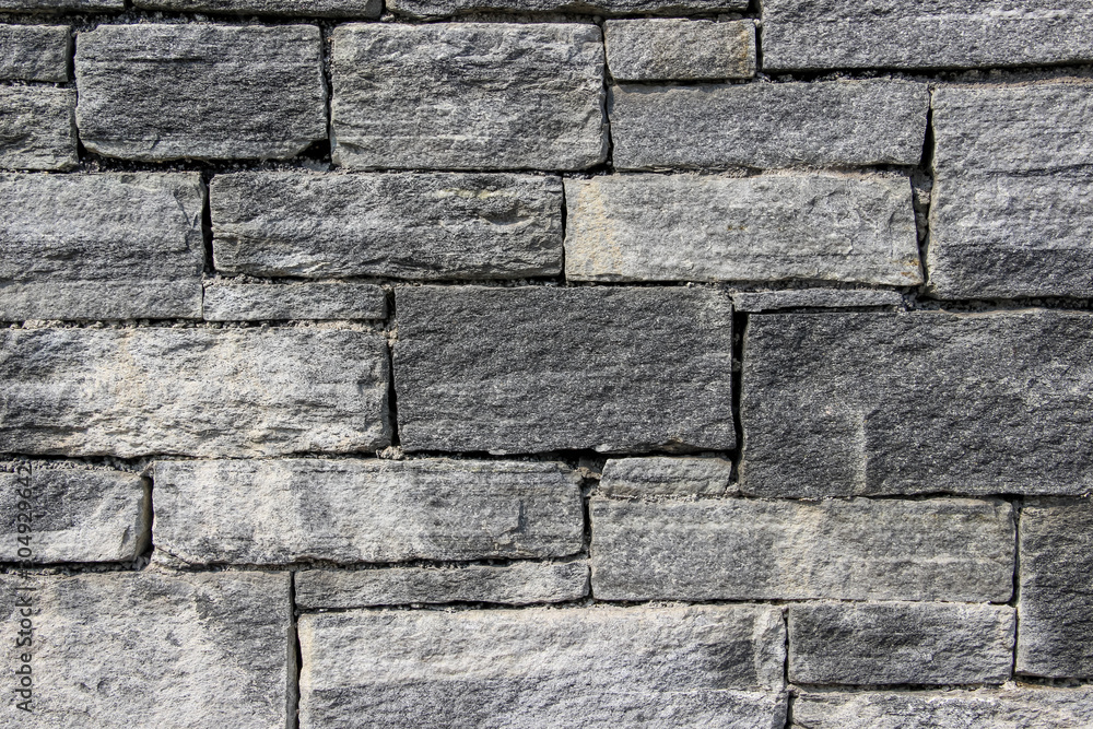 Texture of a wall made of rectangular blocks of different sizes made of natural stones Texture of a wall made of rectangular blocks of different sizes made of natural stones