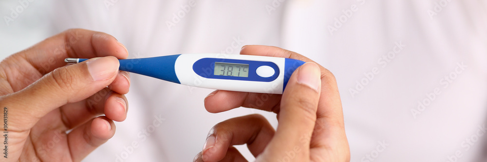 hands of a female doctor holding a thermometer hands of a female doctor holding a thermometer