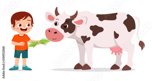 happy cute kid boy feeding cute cow