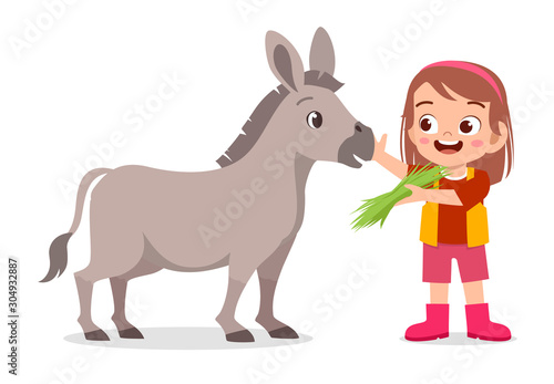 happy cute kid girl feeding cute donkey