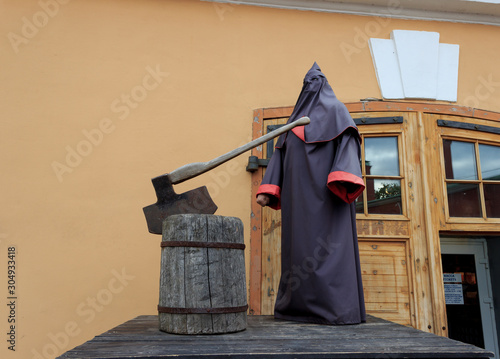 St. Petersburg, Russia - September, 10, 2016: The figure of the executioner in a cloak with a hood, with an ax and chopping block on a platform in the Peter and Paul Fortress.