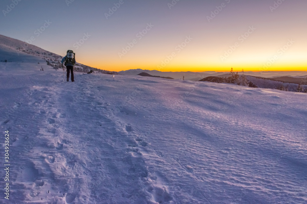 Traveling tourists on the snowy winter mountain ranges of the Ukrainian Carpathians with beautiful views of the evening peaks. Traveling tourists on the snowy winter mountain ranges of the Ukrainian Carpathians with beautiful views of the evening peaks.