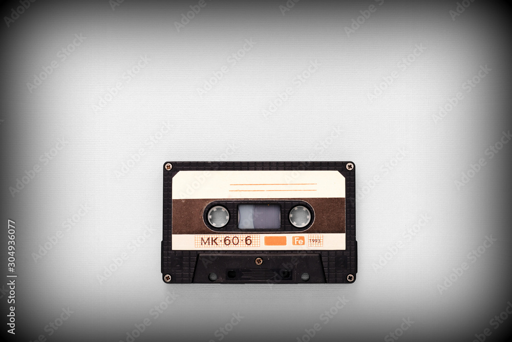 Fototapeta premium Audio tape cassette on a gray background close-up, top view. Old Technology Concept
