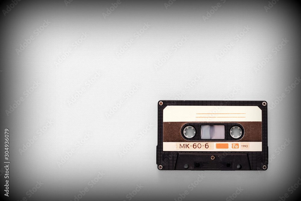 Fototapeta premium Audio tape cassette on a gray background close-up, top view. Old Technology Concept