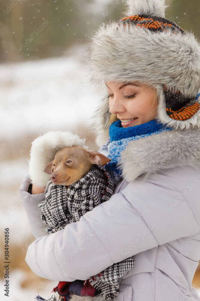 Woman hug warming her little dog in winter Woman hug warming her little dog in winter