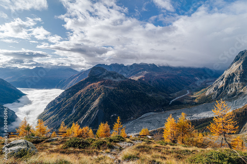 Fantastic autumn mountain landscape. Late fall in the mountians. Yellow grass, meadows and high peaks covered with snow. Autumn in Chamonix and Courmayer area, Mont Blanc, Alps. Beautiful autumn day.