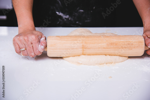 Hand of woman making dough pastry pie with rolling wooden