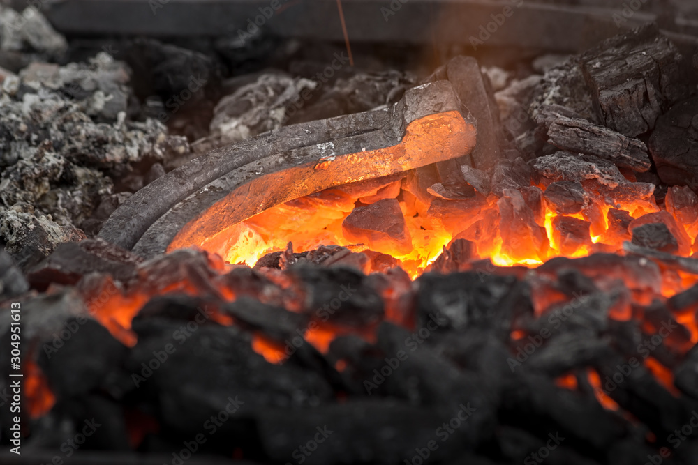 Horseshoe heating for forging. Embers glow in a iron forge. Close view. Horseshoe heating for forging. Embers glow in a iron forge. Close view.