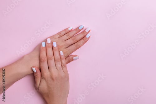Female hands on pink background  top view