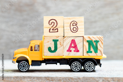 Truck hold letter block in word 26jan on wood background (Concept for date 26 month January)