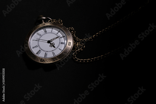 The watch carries an antique bag placed on a black background.