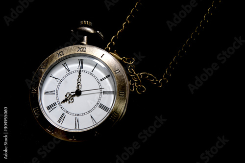 The watch carries an antique bag placed on a black background.