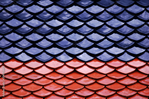 Abstract scene of Red and Blue earthenware tiles or calls tiles consists of fish scales on the roof of temple bangkok thailand - Red and blue separate different concept
