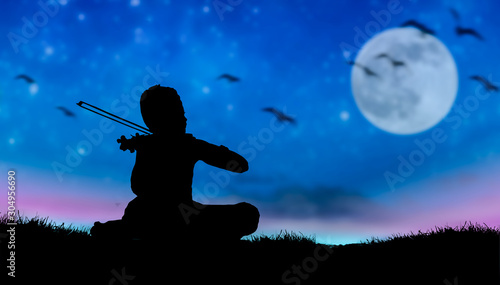 A boy play violin in beautiful moon night.