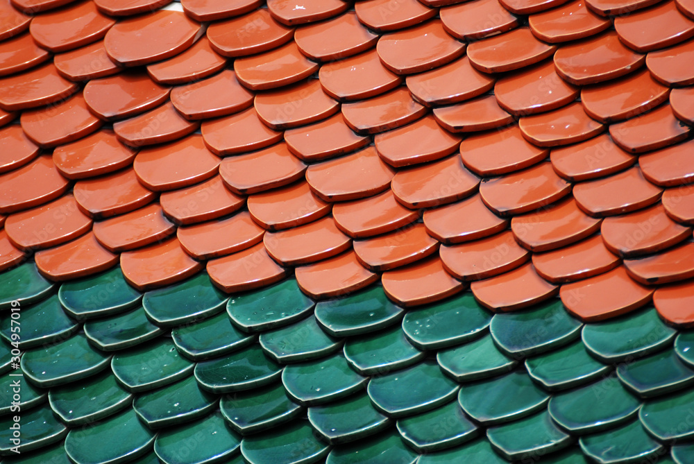 Abstract scene of red Brown and green earthenware tiles or calls tiles consists of fish scales on the roof of temple bangkok thailand - red and green separate different concept Abstract scene of red Brown and green earthenware tiles or calls tiles consists of fish scales on the roof of temple bangkok thailand - red and green separate different concept