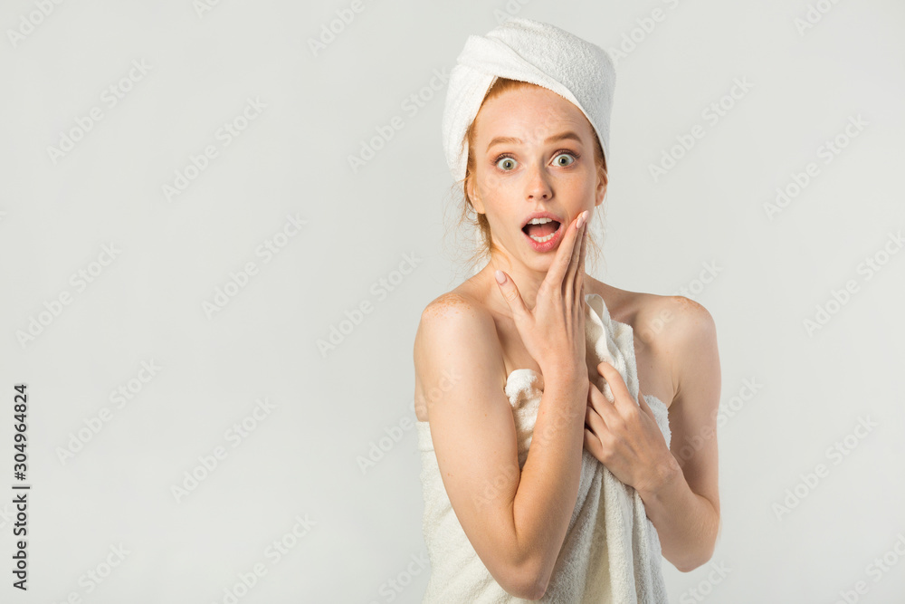 beautiful young woman in a white towel with a scared face