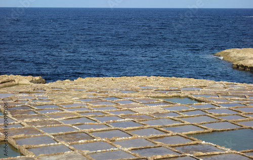 Salt pans in Xwejni, Zebbug, Gozo, Malta, longtime locale for salt production, featuring salt pans in geometric patterns by the ocean photo