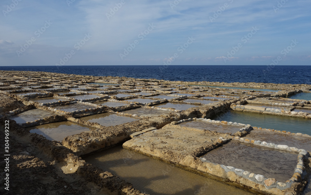 Salt pans in Xwejni, Zebbug, Gozo, Malta, longtime locale for salt production, featuring salt pans in geometric patterns by the ocean