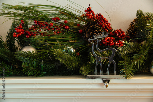 Картината върху платно Christmas fireplace hanger reindeer with green garland cherry and bauballs