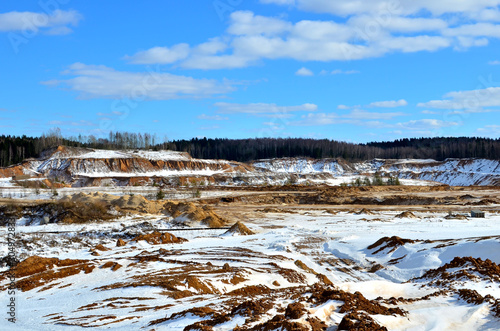 View from the mountain to the red sand in the snow of a small canyon in the Minsk region, Radoshkovichi, the village of Praleski, mining quarry. photo