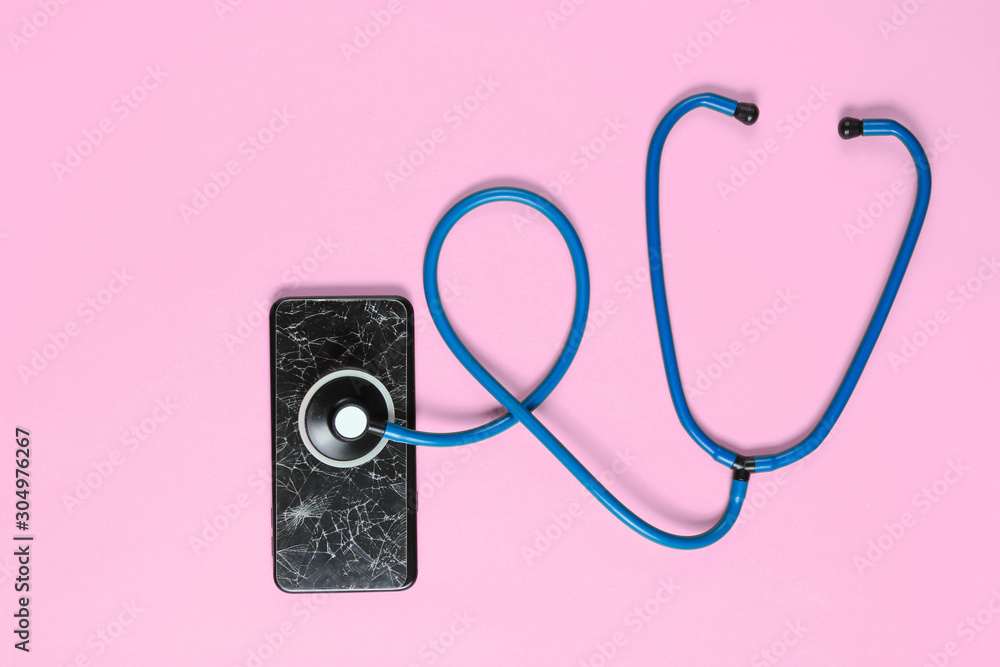The concept of service assistance in the breakdown of smartphone. Broken glass screen of a smartphone, stethoscope on pink background The concept of service assistance in the breakdown of smartphone. Broken glass screen of a smartphone, stethoscope on pink background