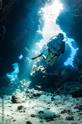 woman diver visiting underwater cave in the Red Sea, egypt, Shaab Claude