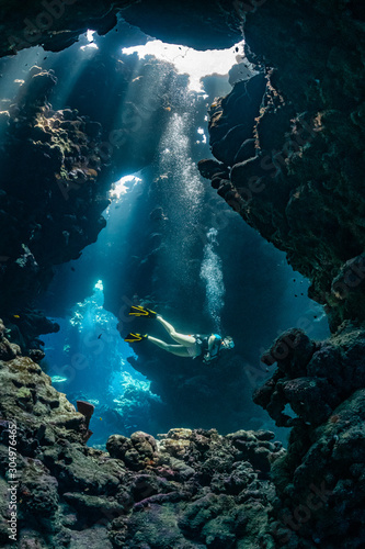 woman diver visiting underwater cave in the Red Sea, egypt, Shaab Claude