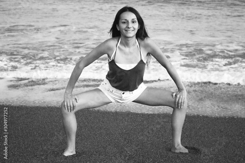 Young athlete woman practicing yoga on the beach