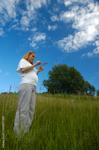 Beautiful pregnant woman relaxing outside in the park