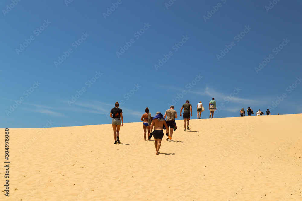 Group of friends walking up a sand dune 2