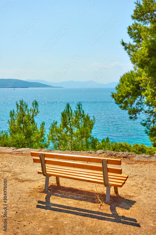 Public park with bench on the coast of the sea