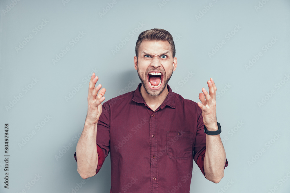 Young man is holding hands up in studio Young man is holding hands up in studio