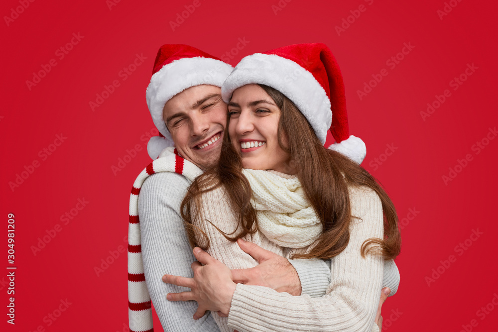 Excited man hugging girlfriend during Christmas celebration Excited man hugging girlfriend during Christmas celebration