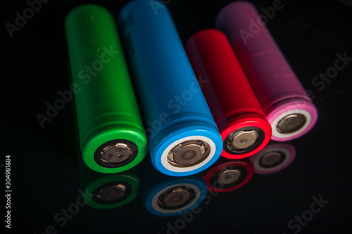 Industrial lithium ion (li-ion) batteries different types and size with reflection on shiny black background