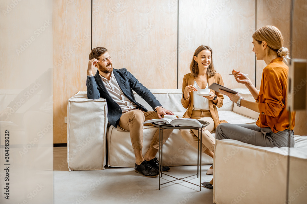 © rh2010 - Young couple talking with woman as sales manager, financial advisor or psychotherapist, sitting on the comfortable couch in the office