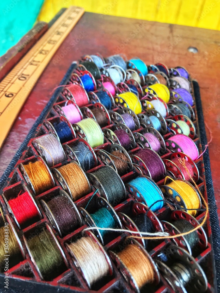 Colors of thread shuttles are preparing for sewing machine. This helps mend cloths.