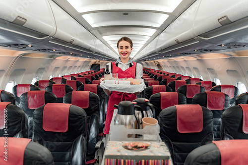 Photography Nice smiling air hostess standing with food tray