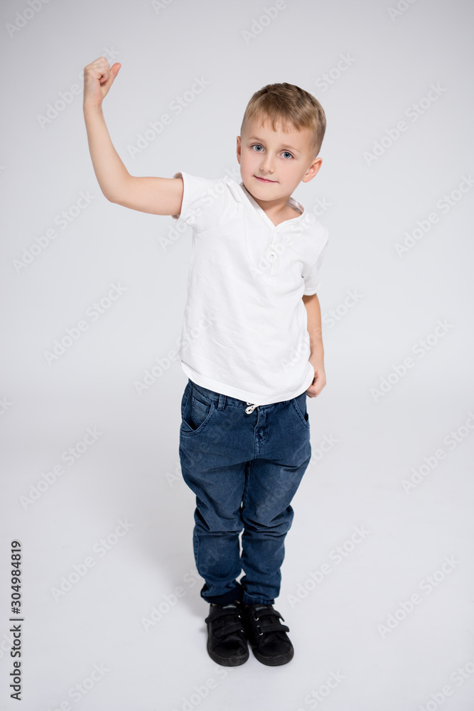 cute little boy showing his muscles over white background