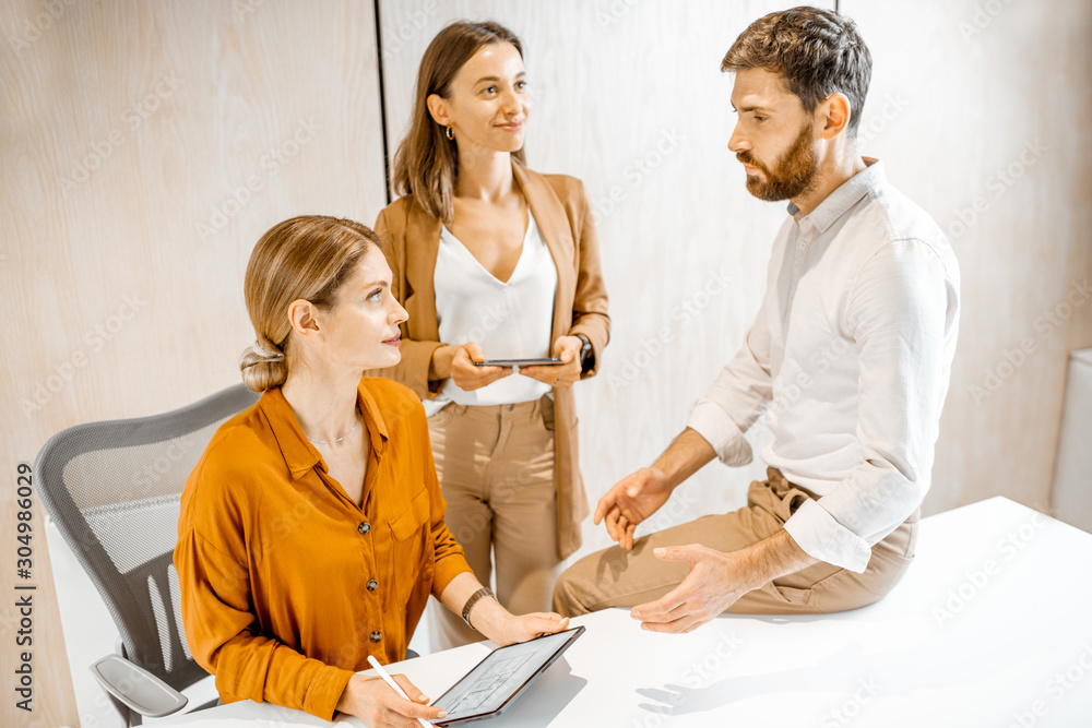 Office employees having some informal conversation at the workplace in the office Office employees having some informal conversation at the workplace in the office